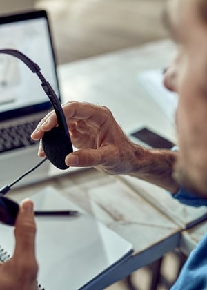 closeup-freelance-worker-using-headphones-office